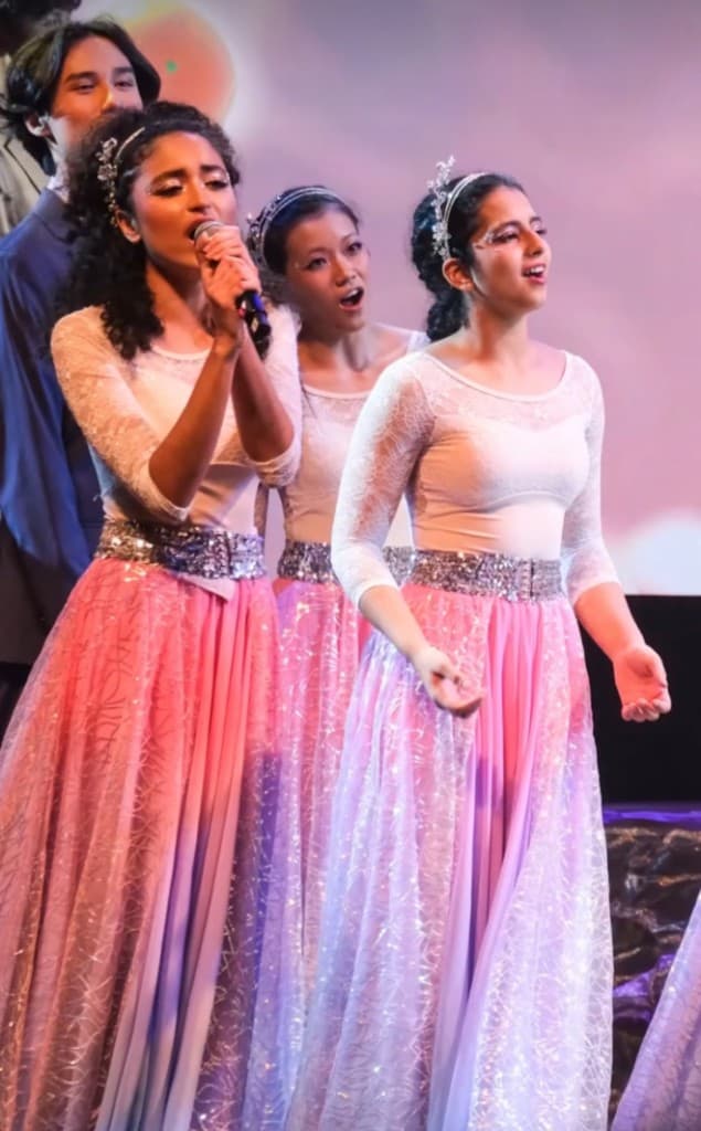 Tara singing on stage with fellow vocalists