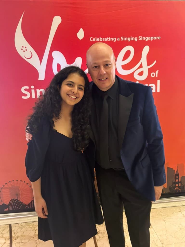 Tara at the Voices Singapore Festival event backdrop with a fellow attendee